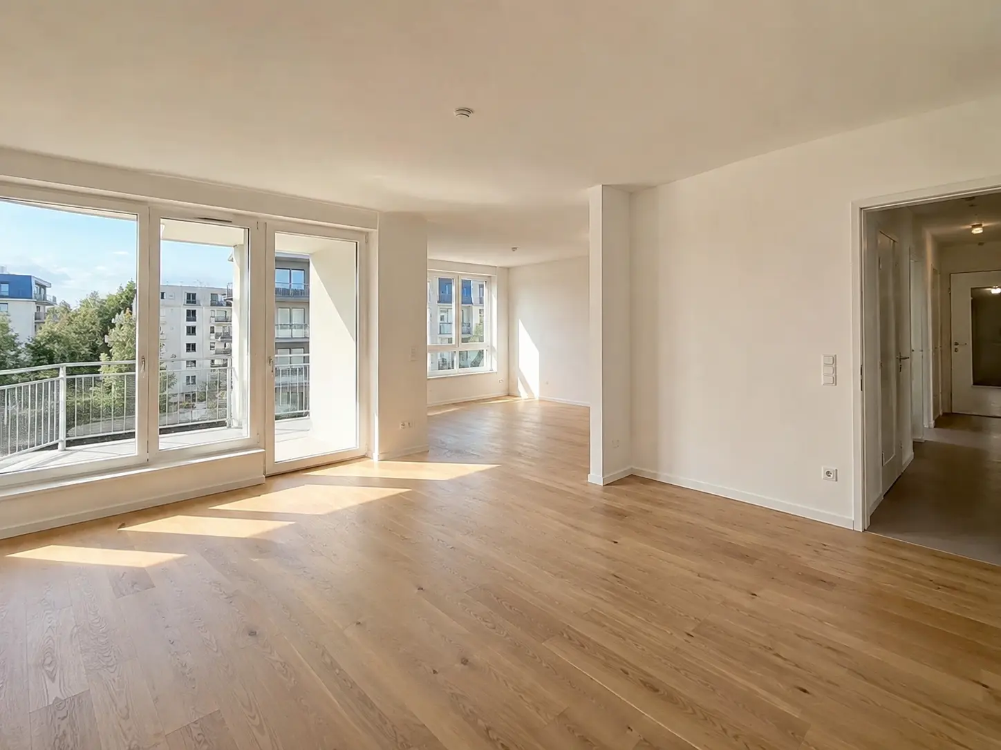 Leerer Wohnraum mit Eichenparkett und bodentiefen Fenstern in einer Eigentumswohnung in Frankfurt am Main