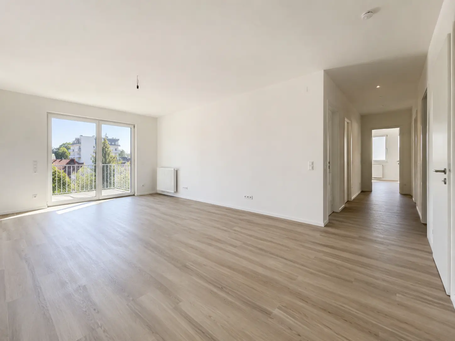 Leerer Wohnraum mit Balkontür und hellem Vinylboden in einer Eigentumswohnung in Frankfurt am Main